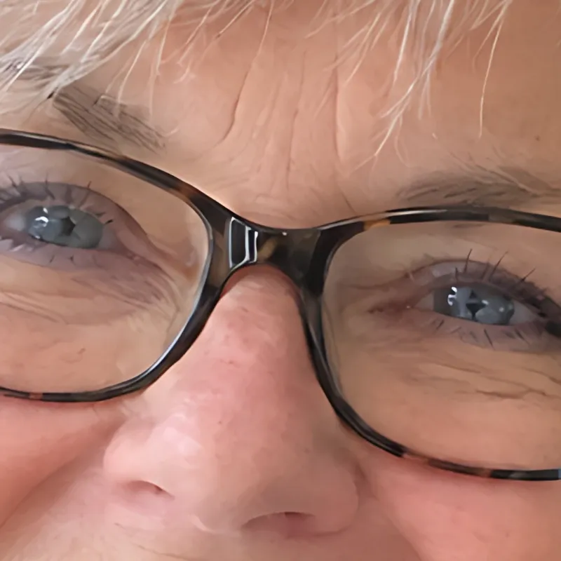 The same detail after the enlargement: the glasses frames, eyelashes and strands of hair have crisp edges again.